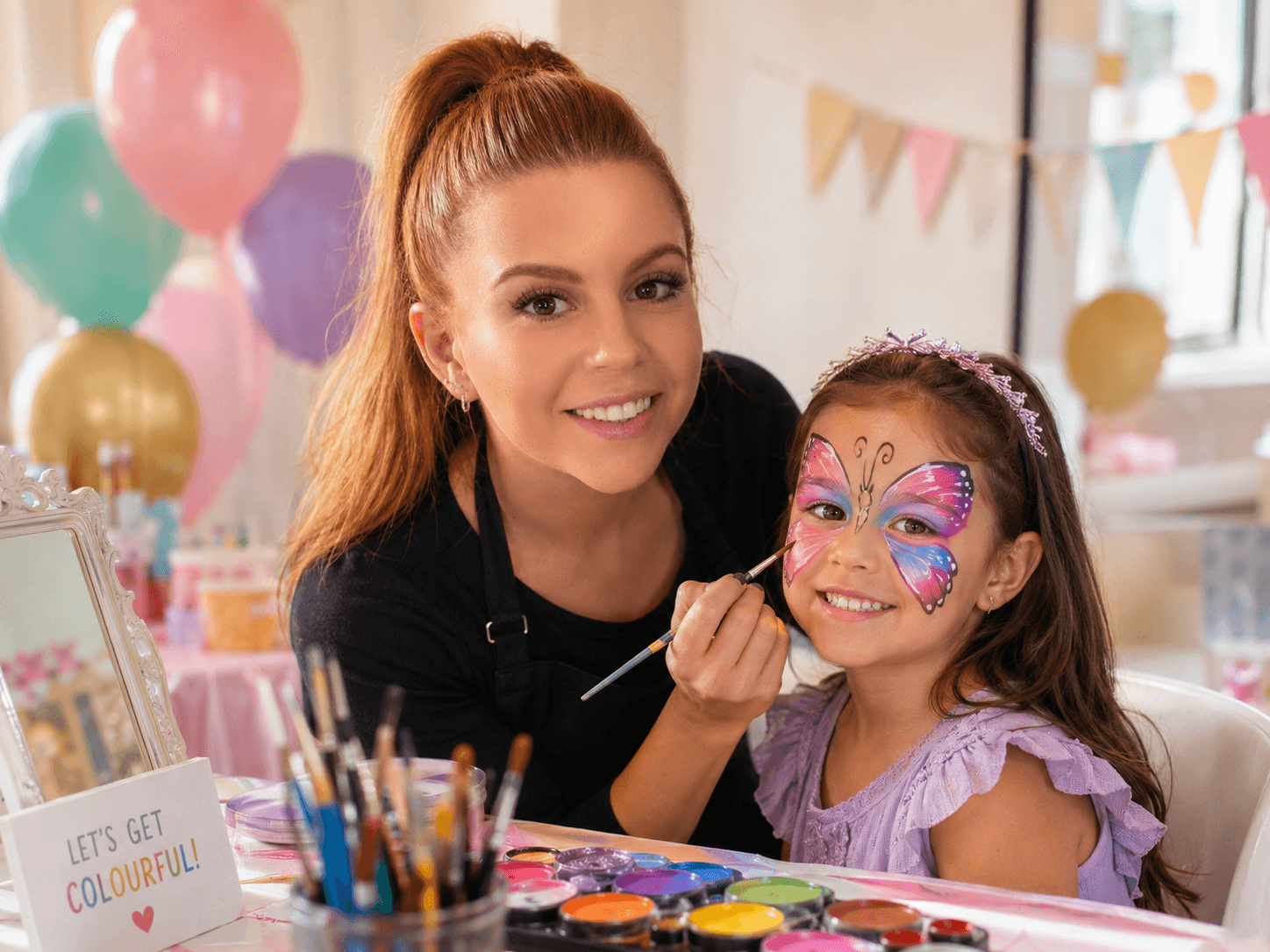 Face painter creating a colourful butterfly design at a children's party